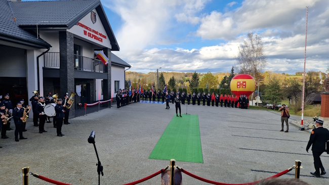 Nowy budynek remizy strażackiej oraz plac przed remiza wypełniony zaproszonymi gośćmi